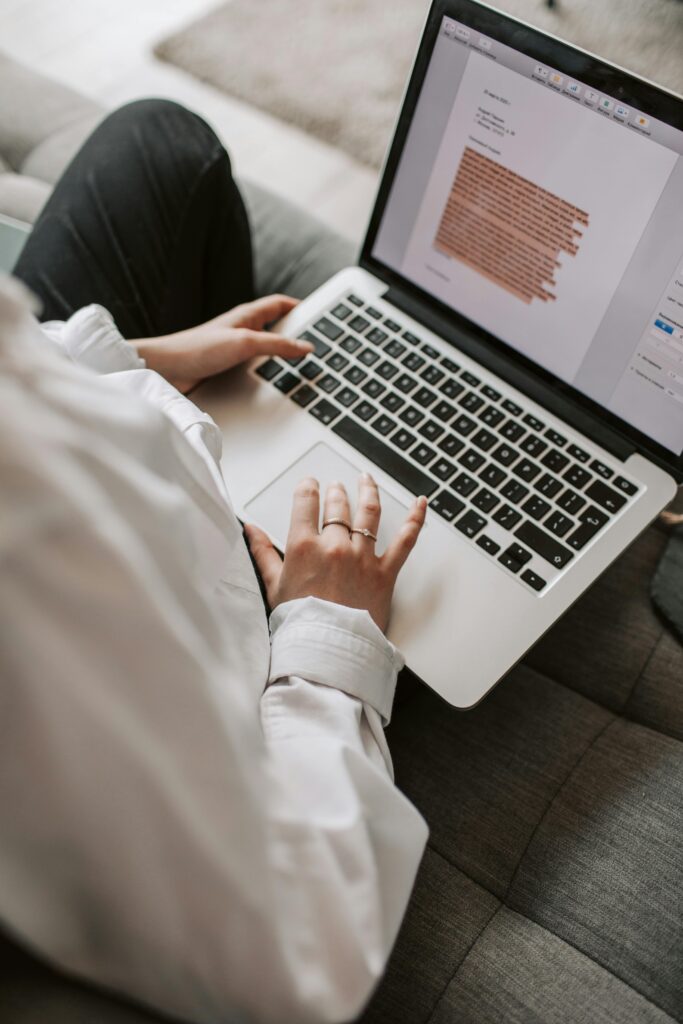 pexels-photo-4050287-4050287 Woman working on a laptop indoors, focusing on document editing and remote work.